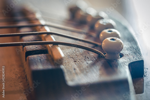 Obraz na plátne Acoustic guitar bridge and strings close up.