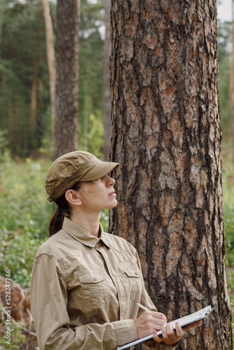Принти на полотні A woman park ranger in uniform with a clipboard control the forest area in summer, vertical photo, selective focus