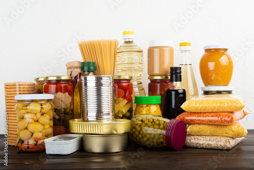 Foto Emergency survival food set on dark wooden kitchen table
