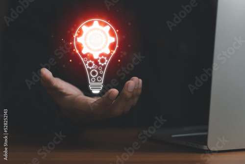Man hand holding virtual light bulb with laptop on desk, vision new idea with innovation and inspiration, innovative technology, connection, communication, corporate strategy planning concept