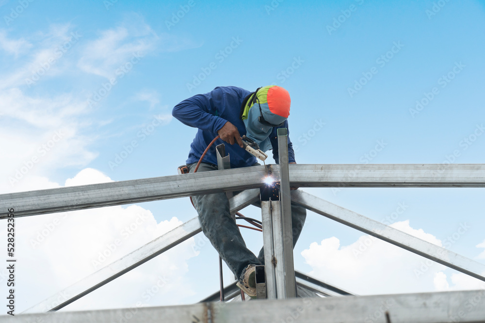 custom made wallpaper toronto digitalConstruction worker : Welding of steel on top of roof structure core. Under the blue sky during the day when the sky is clear. No safety protection and falling from a height.