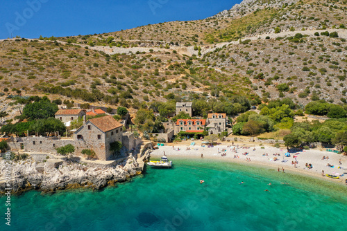 Quadro su tela View on Dubovice Beach on the island of Hvar, Croatia with moored boats and many swimmers