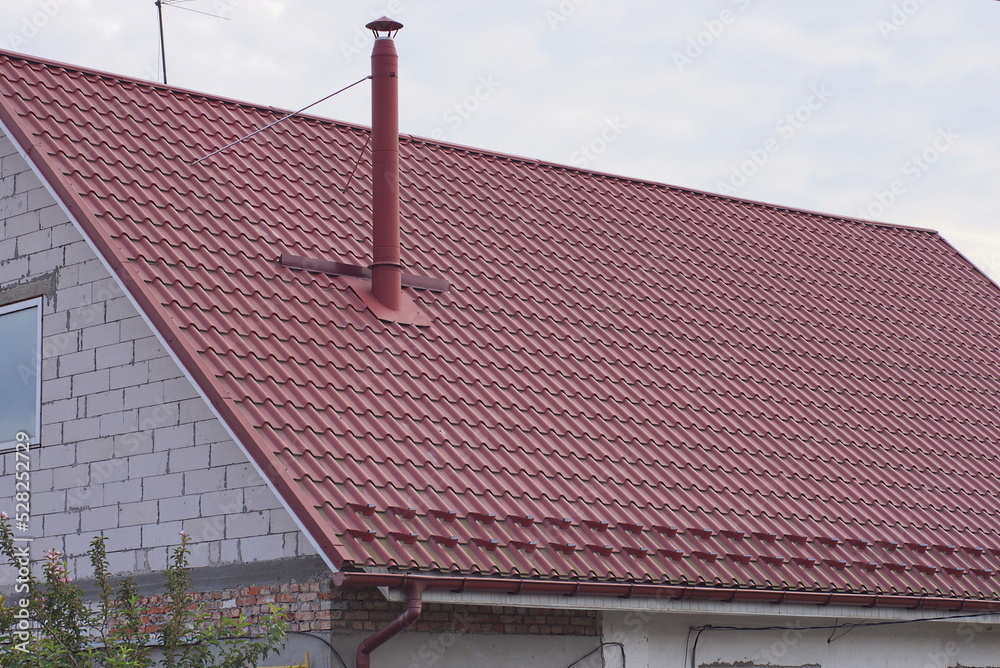 part of a white brick private house under a red tiled roof with a metal ...