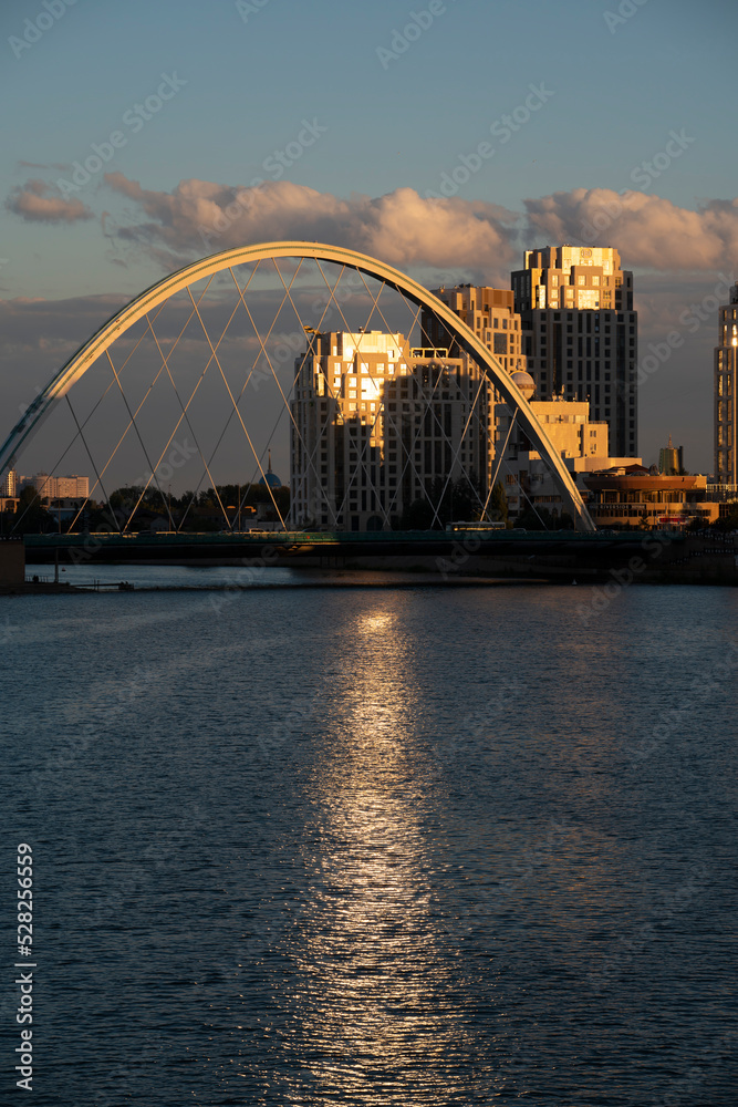 Naklejka premium Nursultan, Kazakhstan, August 2022. View of the bridge on the embankment of the Yesil River at sunset. High quality photo