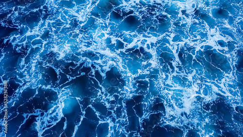 Top view aerial photography white sea foam against the background of the blue sea or ocean. Background, screensaver