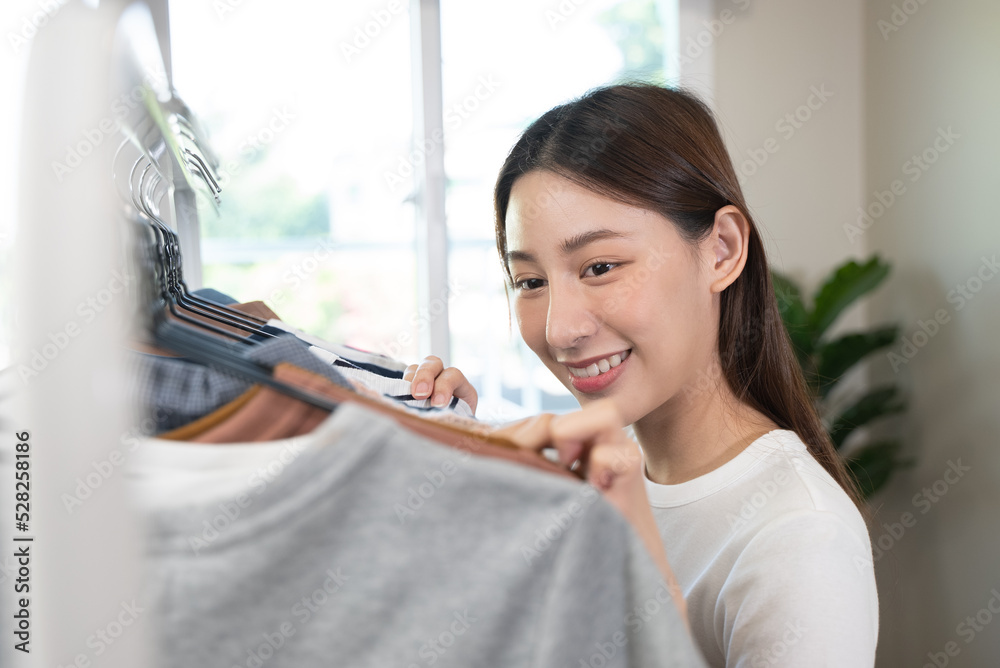 asian female considering cloth to wear on date night. asian female considering cloth to wear on date night.