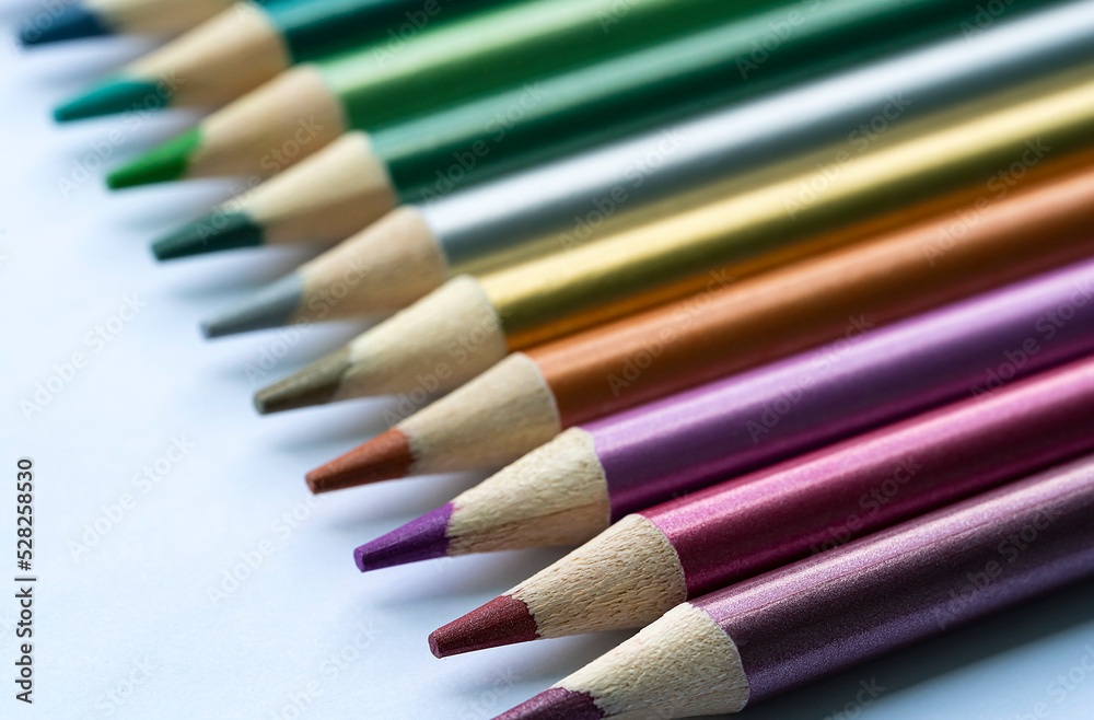 Colored pencils with a metallic sheen close-up. Background with place for text. High quality photo Colored pencils with a metallic sheen close-up. Background with place for text. High quality photo
