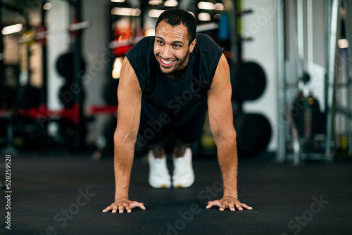 Sporty Black Male Making Straight Arm Plank Exercise While Training At Gym