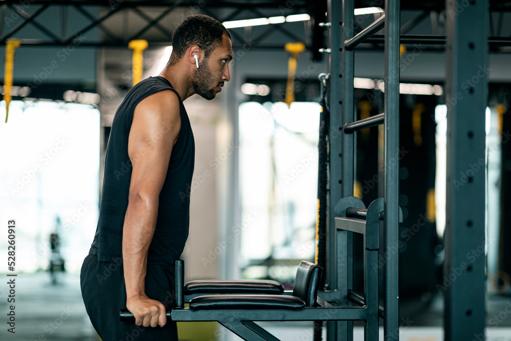 Muscular african american man doing parallel bar dips triceps exercise at gym Muscular african american man doing parallel bar dips triceps exercise at gym