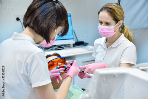 Woman patient with protective glasses and retractor for teeth whitening procedure