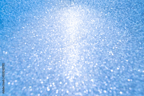 Christmas blue glowlight blur bokeh abstract background.concept happy holiday new year festive glitter backdrop.
