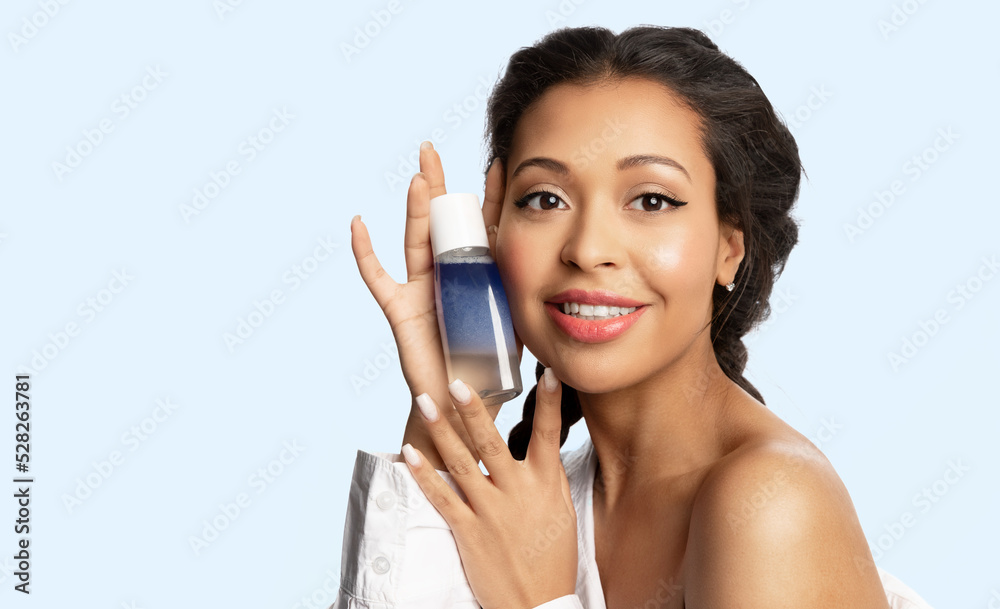 Happy beautiful mixed race girl hold jar template with micellar water for cleansing glowing healthy skin. Pretty woman with mock-up bottle of lotion for removing make up. Skincare cosmetics ad. Happy beautiful mixed race girl hold jar template with micellar water for cleansing glowing healthy skin. Pretty woman with mock-up bottle of lotion for removing make up. Skincare cosmetics ad.