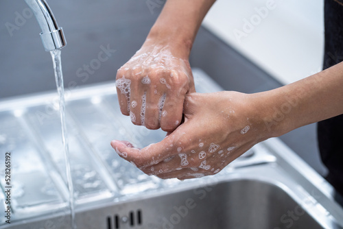 Woman is washing her hands with foam soap and clean water. Woman washing hands with soap in sink for prevent the spread of viral