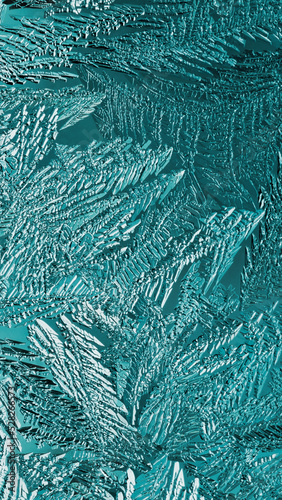 Abstract Christmas winter background. Ice crystals on frozen window glass. Frost drawing. A pattern of leaves and stems of fantastic plants. Turquoise mobile phone wallpaper. Cold and crystal. Macro