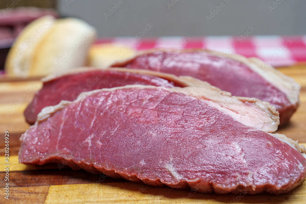 pedaços de picanha fatiados e colocados sobre a tábua de madeira para serem assados. Preparação para churrasco. pedaços de picanha fatiados e colocados sobre a tábua de madeira para serem assados. Preparação para churrasco.
