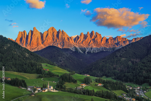 St. Magdalena village with magical Dolomites Odle mountain ridge in golden hour of sunset with alpenglow, Val di Funes valley, South Tyrol, Italian photo