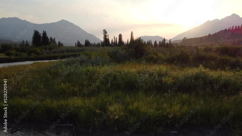 Low aerial sunset shot over with distant Canadian Rocky Mountains in the Crowsnest Pass.
