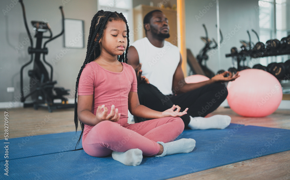 Naklejka premium children exercise yoga with family at the gym.The lifestyle of a young body is to take care of one's body.Children wear sports wear to exercise fluently.