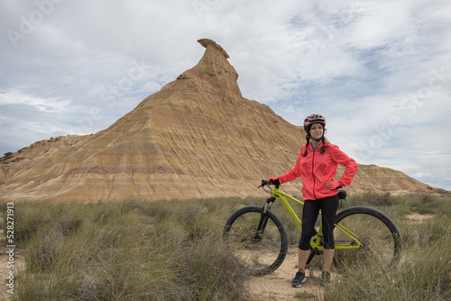 Fototapeta Young woman mountain bike cyclist in Badlans of Navarre (Bardenas Reales de Navarra) dessert in the middle of Spain