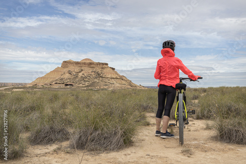 Obraz na plátně Young woman mountain bike cyclist in Badlans of Navarre (Bardenas Reales de Navarra) dessert in the middle of Spain