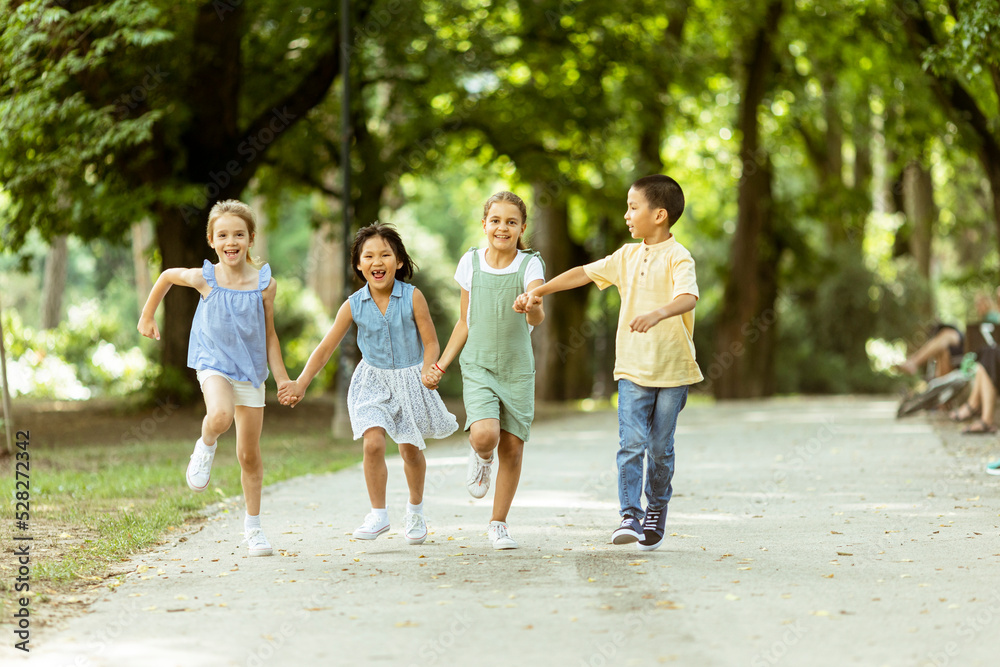 Group of asian and caucasian kids having fun in the park