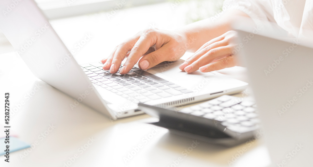 female hands use a laptop in the office. female hands use a laptop in the office.