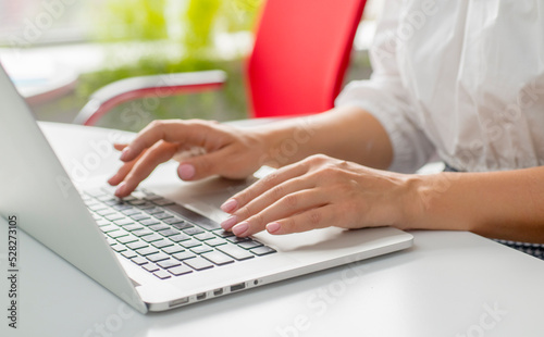 female hands use a laptop in the office.