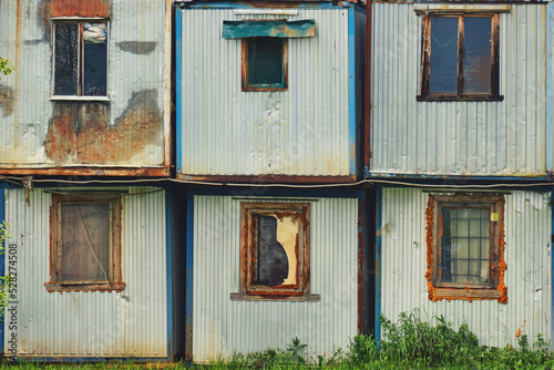 Old construction cabins with dirty windows. Temporary housing for builders