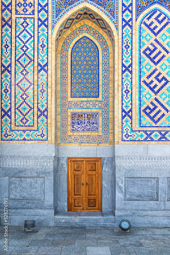 An arched niche and a small carved wooden door with Central Asian ornaments