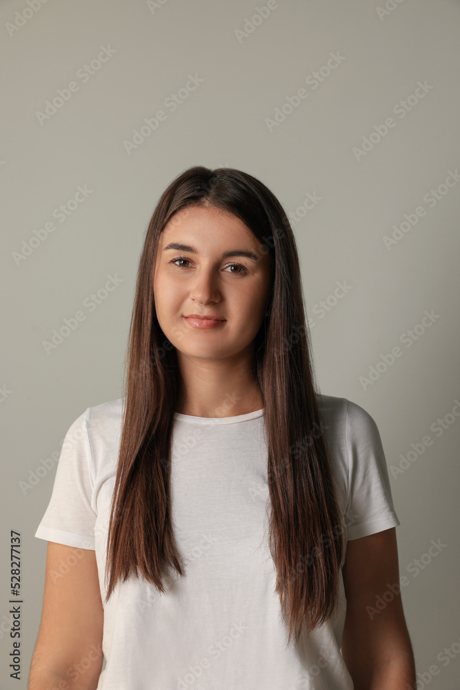 Beautiful young woman in white t-shirt on light background Beautiful young woman in white t-shirt on light background