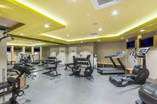 A spacious  bright gym in the wellness center with a variety of sports equipment.
