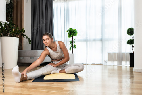Young woman rehabilitation exercise at home after car crash accident. Recovery workout of young girl with yoga training poses for stretching the muscles. Female after childbirth relaxing.