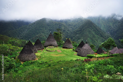 Low cloud over traditional Mbaru Niang houses in mountain, Wae Rebo Village, Manggarai District, Flores Island, Indonesia photo