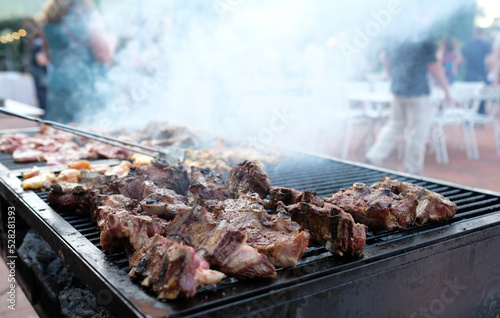 Fotografia Smoking barbecue grill with numerous pieces of meat on it