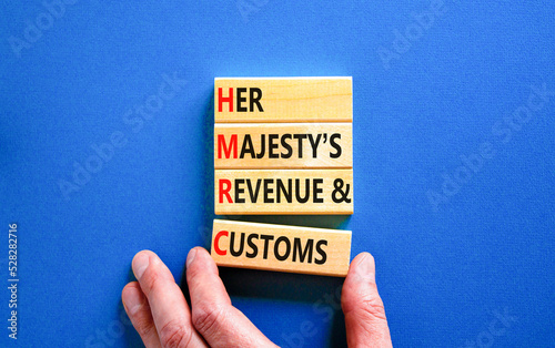 HMRC her majestys revenue and customs symbol. Concept words HMRC her majestys revenue and customs on blocks on beautiful blue background. Business HMRC revenue and customs concept. Copy space. photo