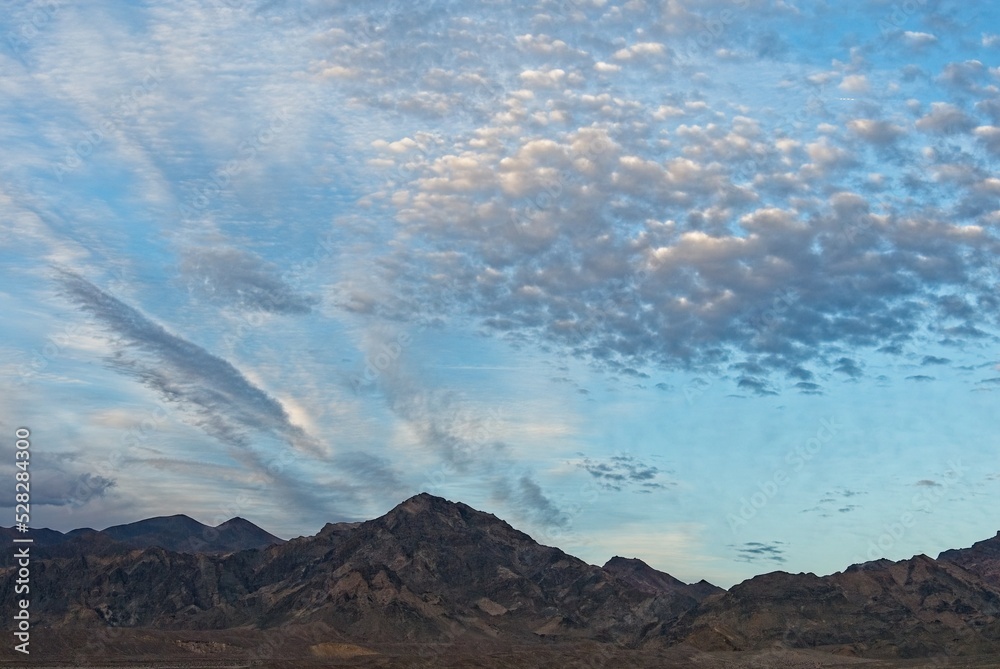 Tableau sur toile Illuminated altocumulus clouds at sunset over badlands in Death Valley National