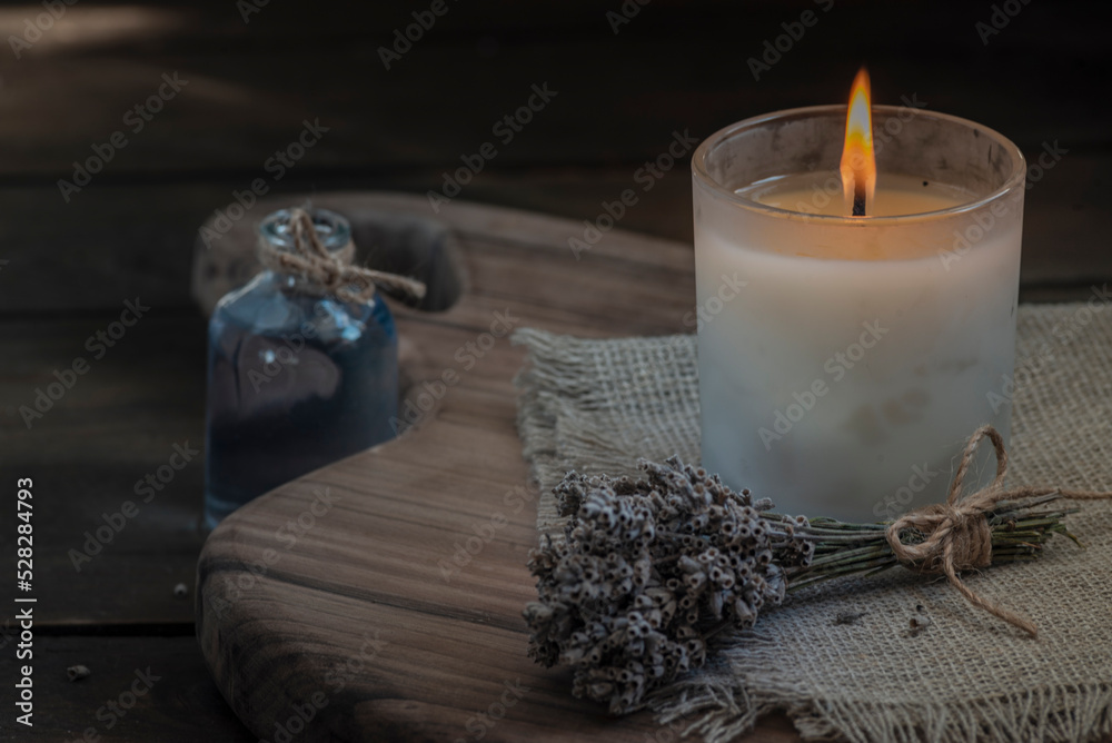 Burning white candle light on old dark wooden table background burlap sack  Halloween Aromatherapy smoke rustic cutting board napkin christmas cozy  textile. Stock Photo | Adobe Stock