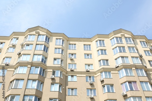 Exterior of multi storey apartment building against blue sky, low angle view
