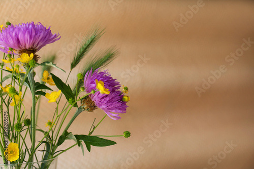 Bouquet of beautiful wildflowers on beige background, closeup. Space for text