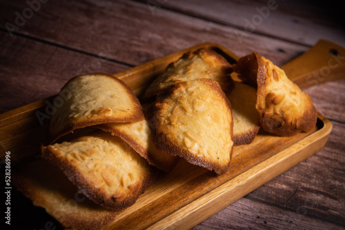 French delicacy pastry tuile with almond on wood background, High quality photo