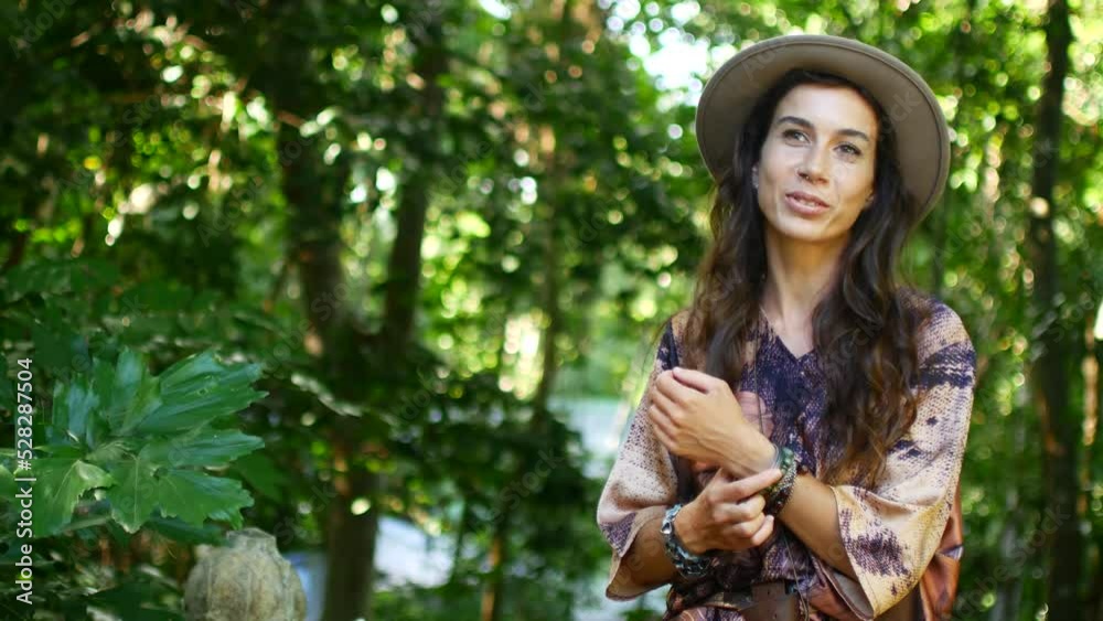 Portrait of a young brunette in a hat against the backdrop of a green park Portrait of a young brunette in a hat against the backdrop of a green park