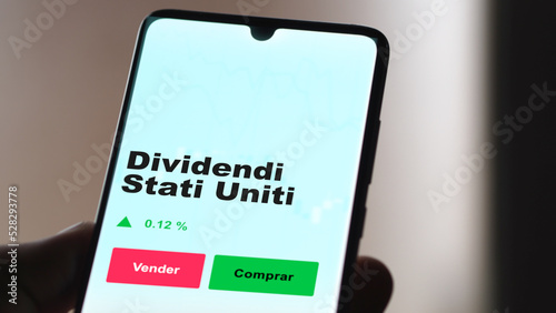 Un inversor está analizando el dividendi stati uniti etf fondo en pantalla. Un teléfono muestra los precios del ETF para invertir.