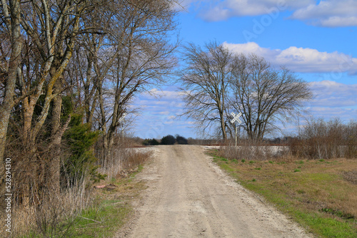 single lane dirt country road lane rural countryside train tracks railroad crossing empty deserted driveway