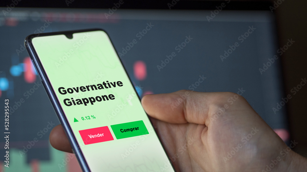 Un inversor está analizando el governative giappone etf fondo en pantalla. Un teléfono muestra los precios del ETF para invertir.