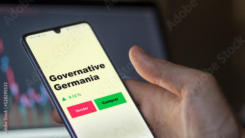 Un inversor está analizando el governative germania etf fondo en pantalla. Un teléfono muestra los precios del ETF para invertir.