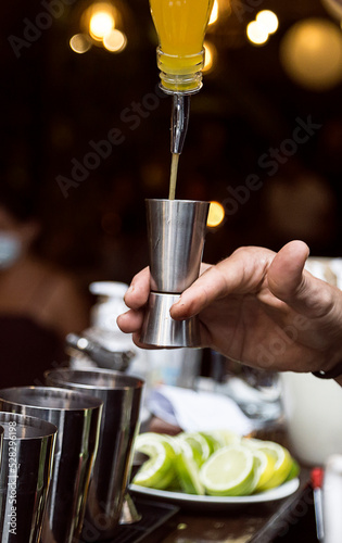 Bartender serving alcohol in a cocktail. Cocktail preparation in a night environment. It can be a hotel, a restaurant or a night club.