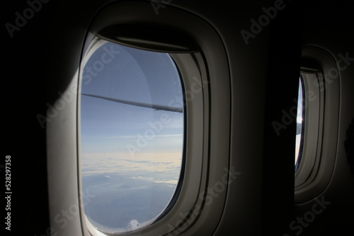 View through two windows of a plane on a sunny sky.