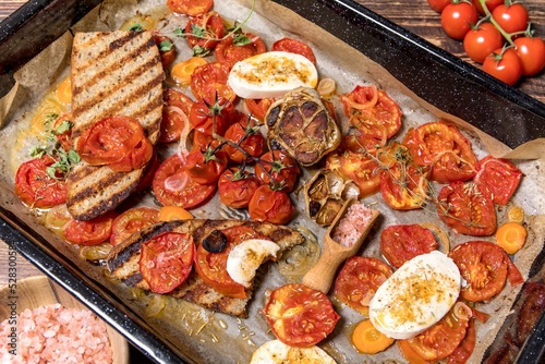 Baked tomatoes with olive oil and herbs in a baking dish. Healthy food. Summer food on the grill.