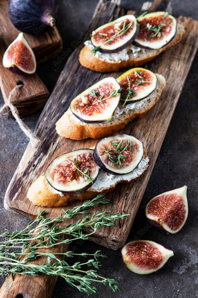Breakfast with figs, cream cheese and honey toasts on a wooden board Breakfast with figs, cream cheese and honey toasts on a wooden board