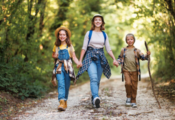 happy family mother and children with backpacks went hiking in   forest